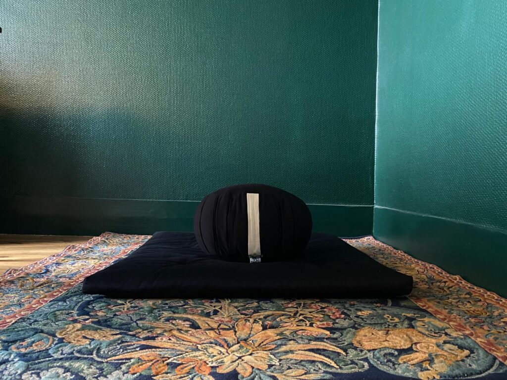 Photographie d'un zafu posé sur un zafuton pour illustrer un dojo, un lieu de pratique de la méditation.